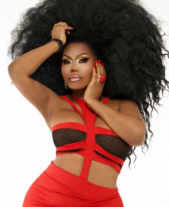Drag performer in a bold red and black outfit with voluminous black hair for Palace South Beach in Miami Beach
