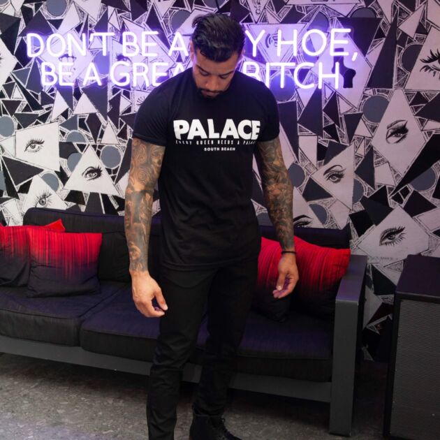 Two men wearing matching pink Palace South Beach t-shirts outside the iconic drag bar and restaurant