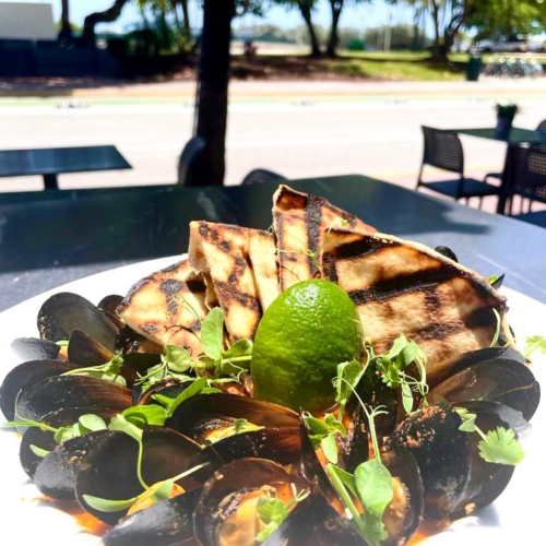 Dish of mussels served with pita bread and dipping sauce