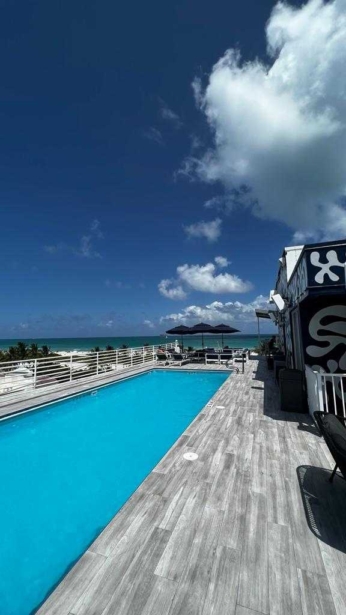 Rooftop pool at Palace South Beach with the ocean in the background