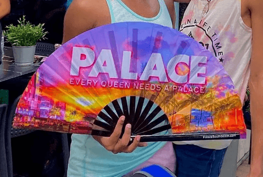 Hand holding a Palace-branded clacking fan