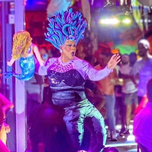 Olga Dantelly performing as Ursula holding a mermaid prop at Palace South Beach