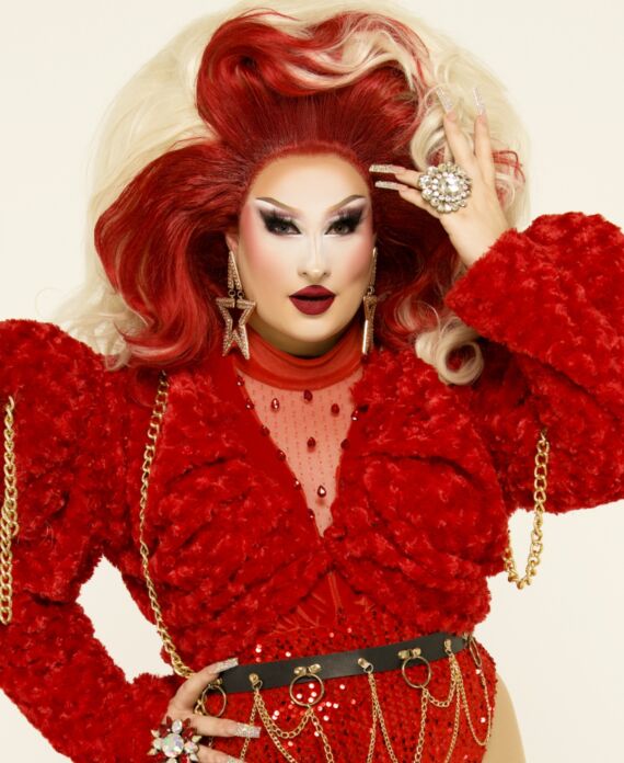Drag performer in a bold red textured outfit with dramatic red and blonde hair for Palace South Beach in Miami Beach
