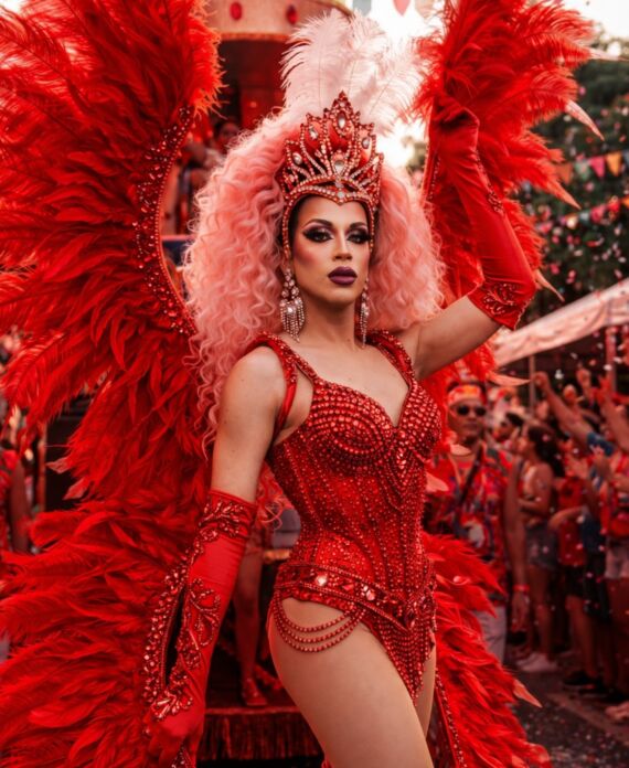 Valentina Valentino in an elaborate red feathered costume and jeweled crown at a Palace South Beach event in Miami Beach