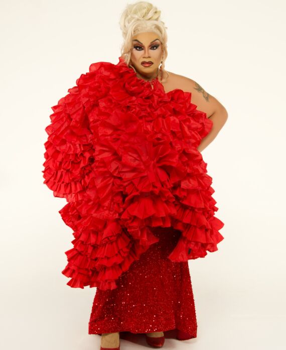 Drag performer in a dramatic red ruffled and sequined gown for Palace South Beach in Miami Beach
