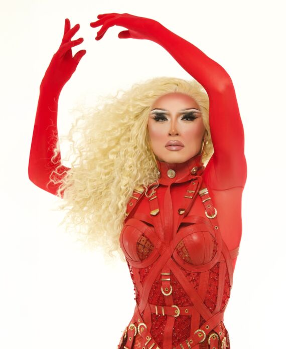 Drag performer in a striking red embellished costume with long blonde curls for Palace South Beach in Miami Beach