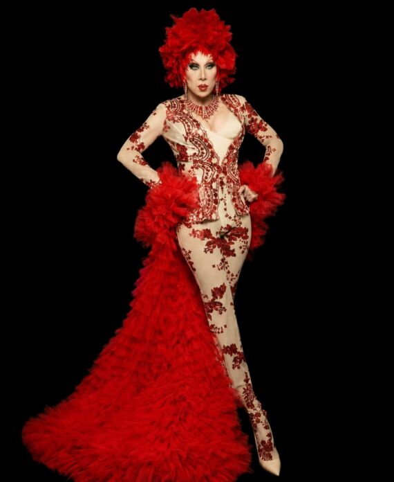 Drag performer in an elaborate red feathered costume and floral bodysuit for Palace South Beach in Miami Beach