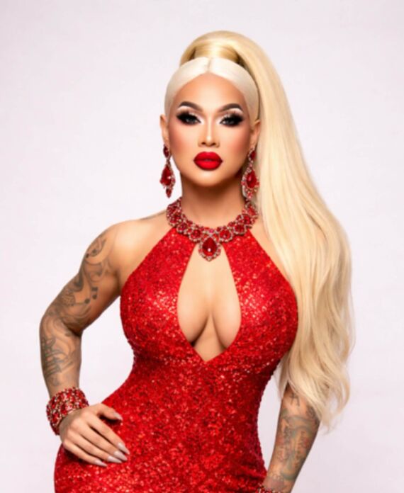 Drag performer in a sparkling red gown with blonde hair and red jewelry for Palace South Beach in Miami Beach